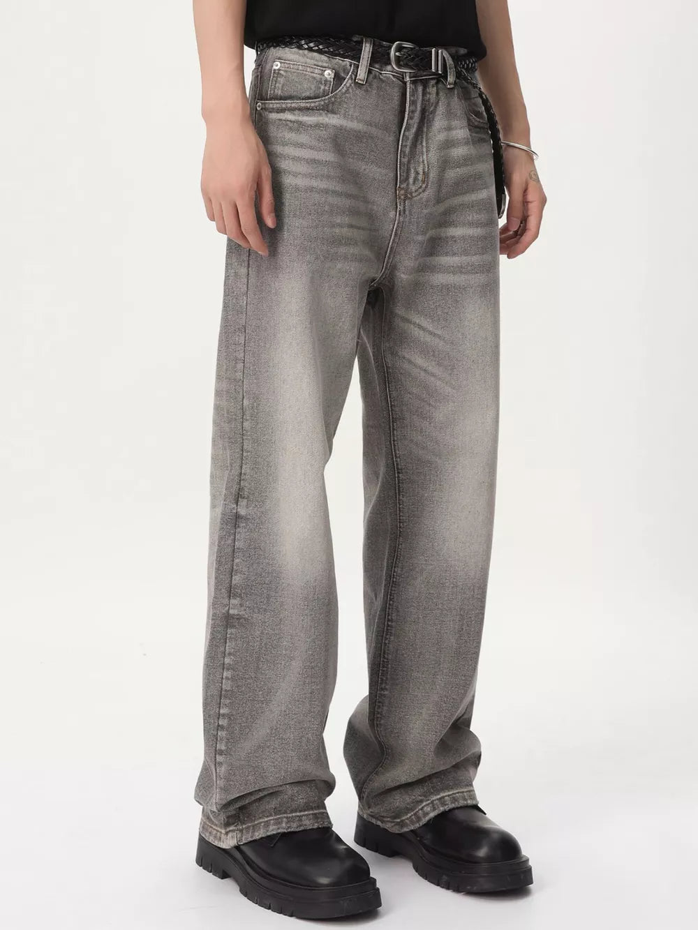 Men's vintage wash wide leg jeans in gray cotton, styled with a black belt.
