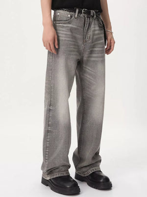 Men's vintage wash wide leg jeans in gray cotton, styled with a black belt.