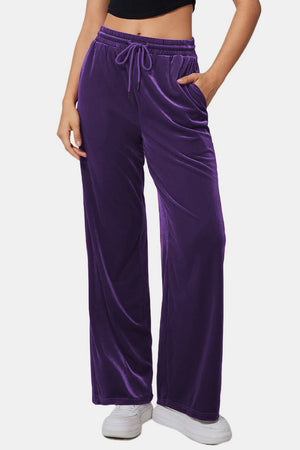 Velvet palazzo lounge trousers in violet with drawstring waist and pockets.