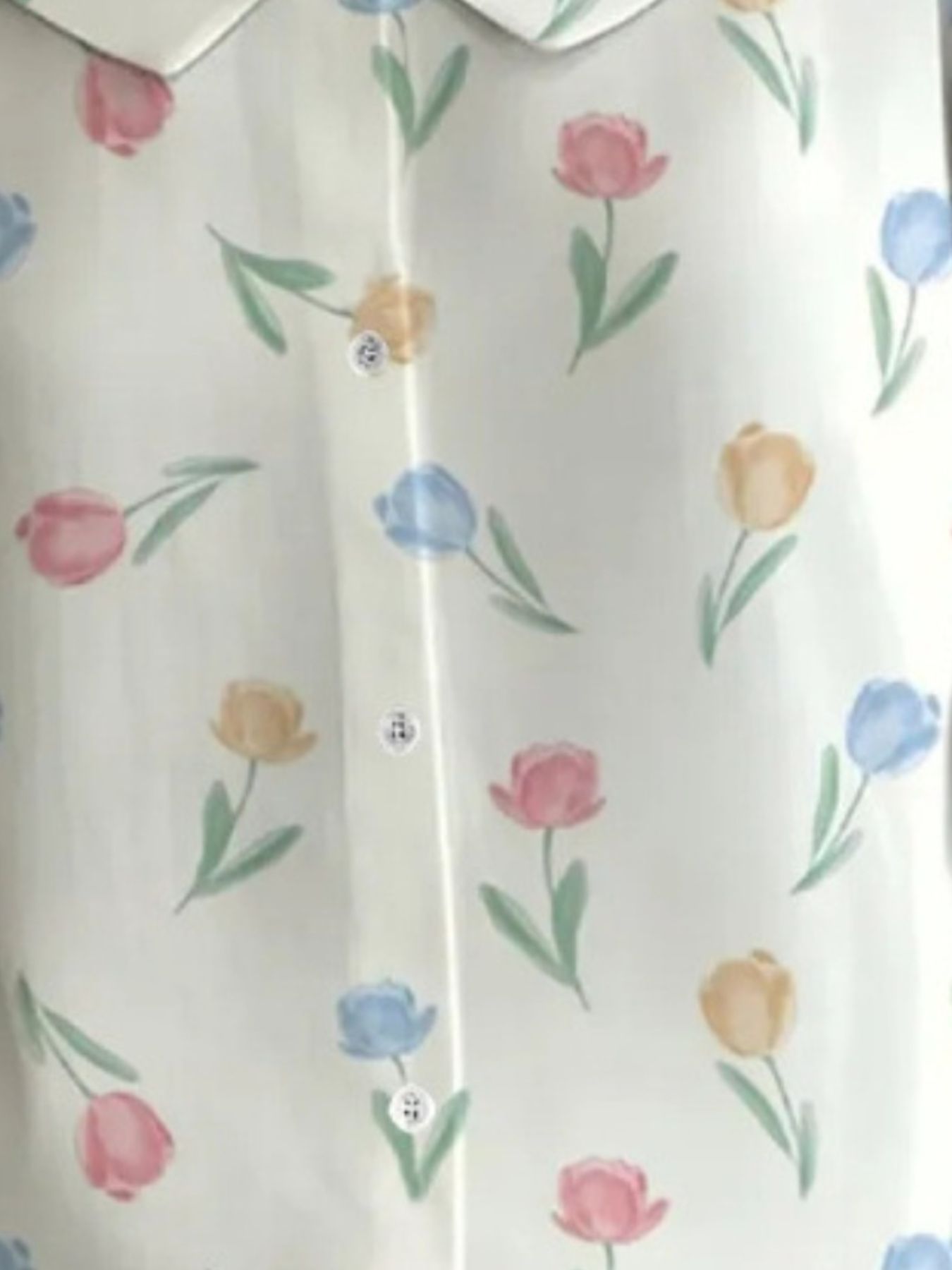 Peter Pan collar blouse with a floral tulip print in pink, blue, and yellow on a white background.