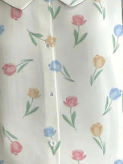 Peter Pan collar blouse with a floral tulip print in pink, blue, and yellow on a white background.
