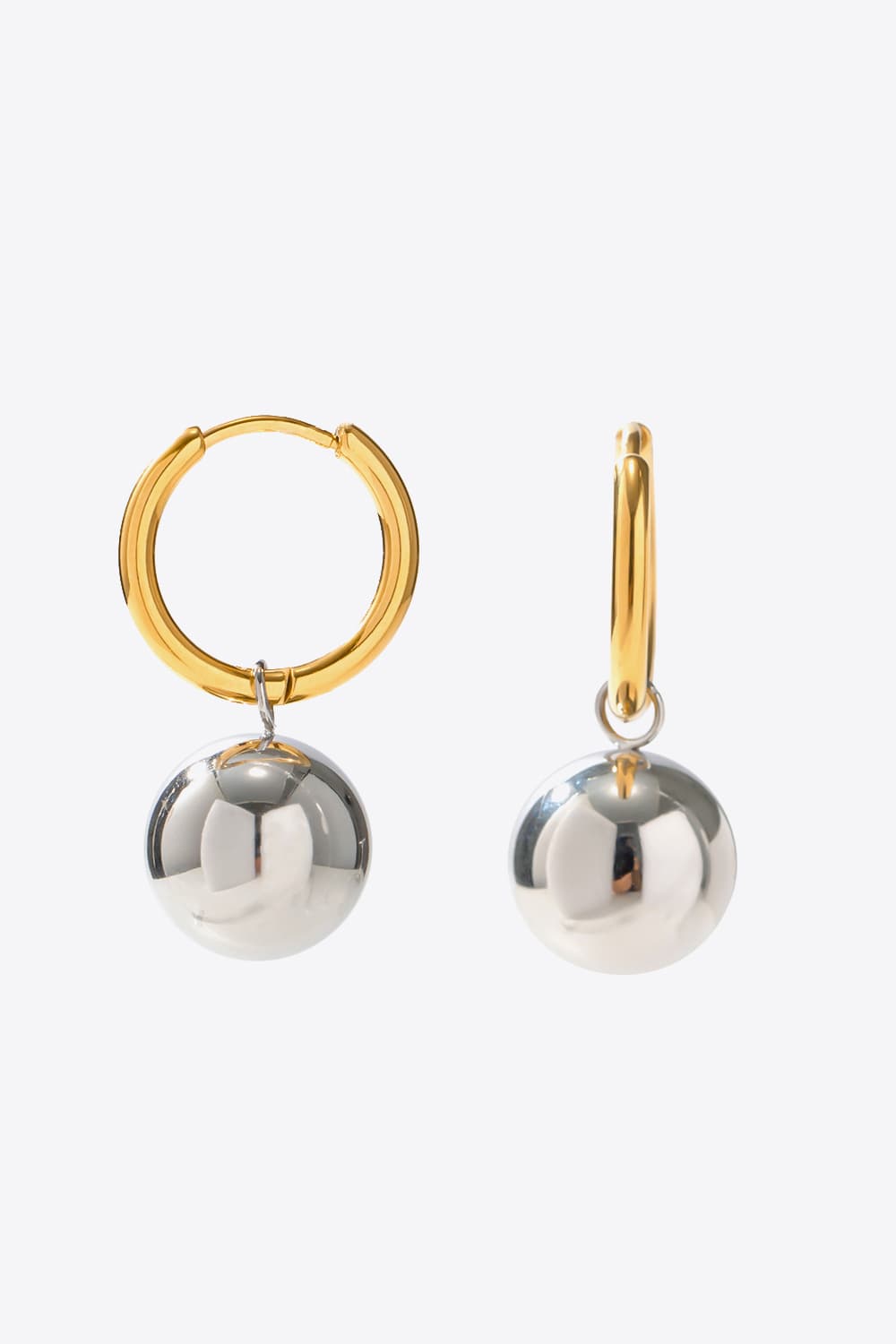 Orbital gold and silver drop earrings with large spherical charms.