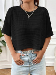Black waffle-knit cropped t-shirt with crew neck and short sleeves.