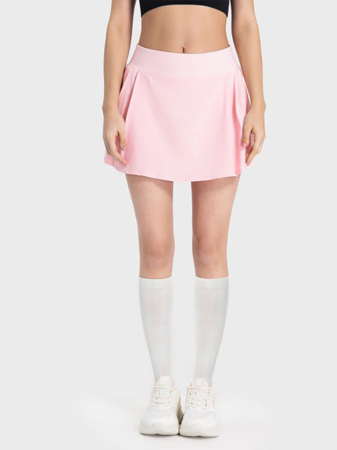 Pleated performance mini skirt in blush pink with a flared hem.