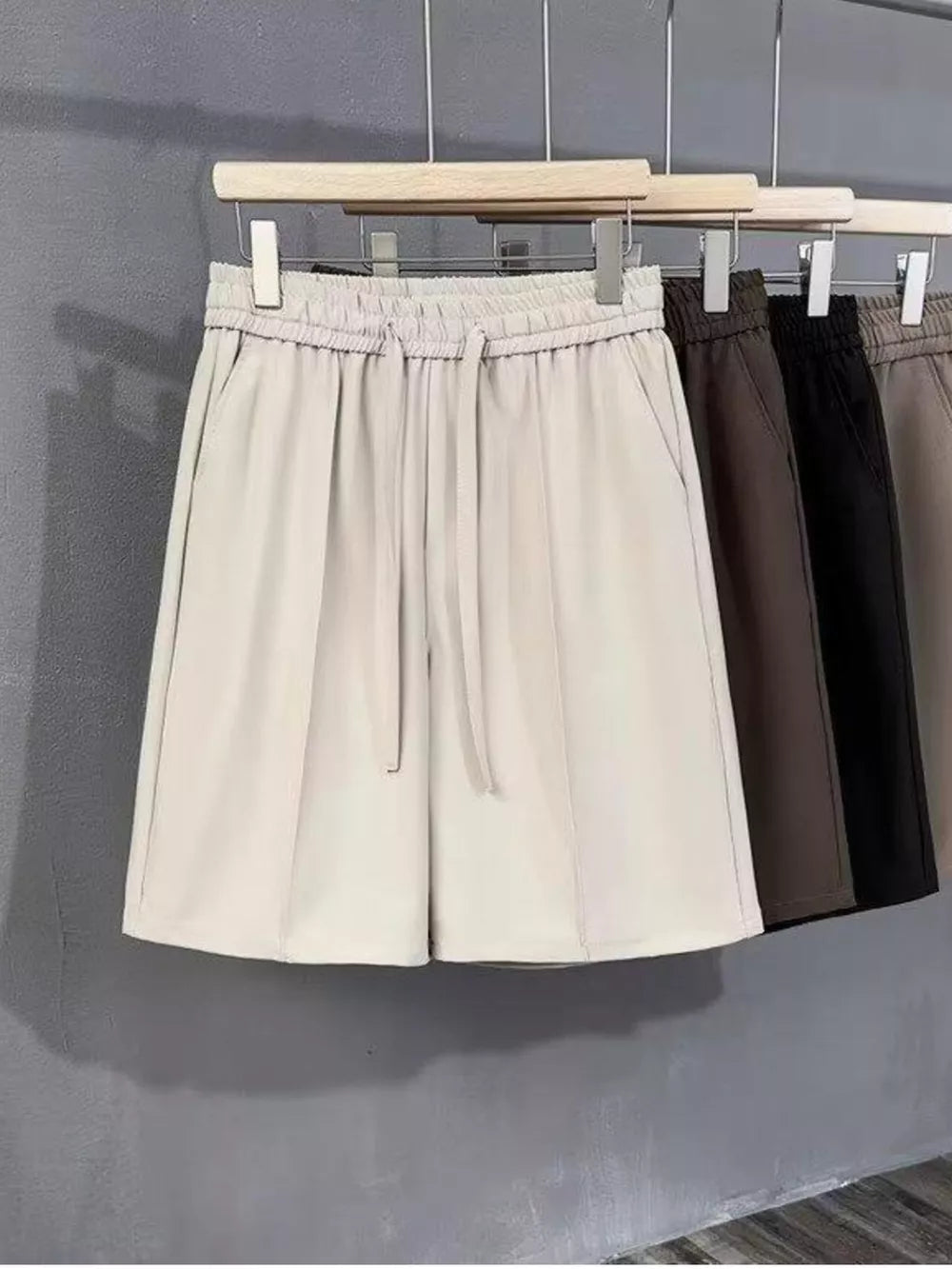 Men's ivory chino shorts with drawstring waist and pleats, shown with other colors.