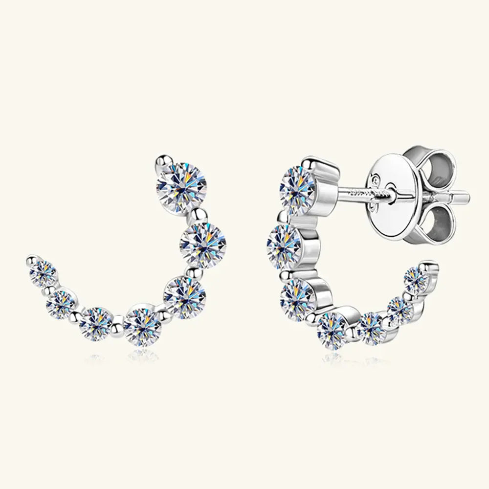 Silver moissanite arc stud earrings with sparkling cubic zirconia accents.