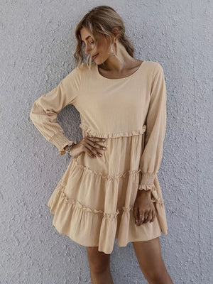 Apricot ruffled mini dress with long sleeves and tiered skirt.