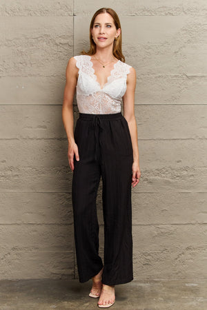White lace plunge bodysuit with scalloped trim and a built-in bra.