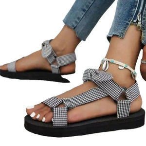 Bow-tie platform sandals in black and white plaid with ankle strap detail.