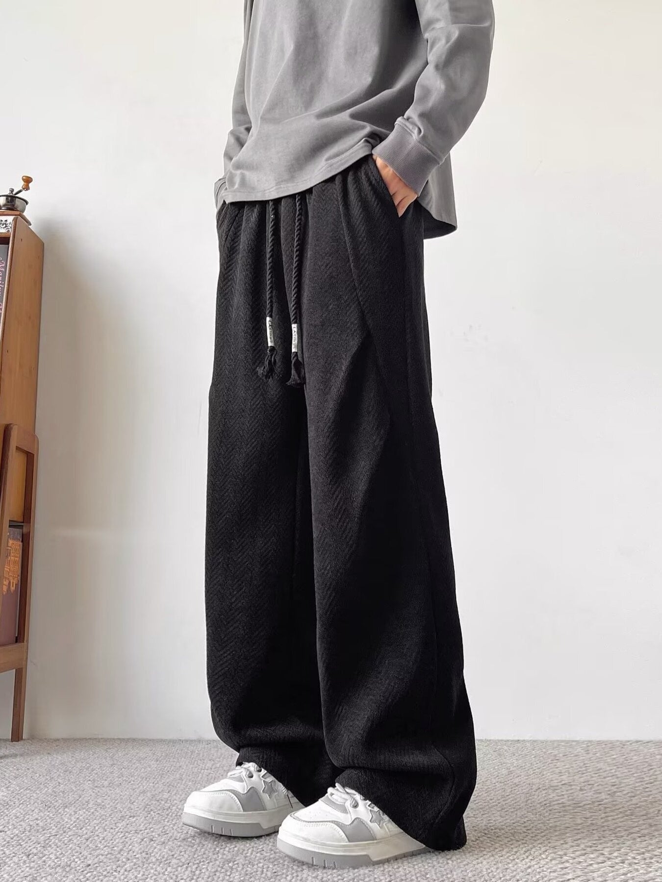 Black herringbone drawstring sweatpants with a relaxed fit.