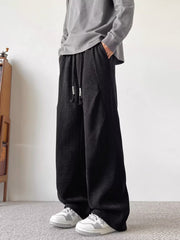 Black herringbone drawstring sweatpants with a relaxed fit.