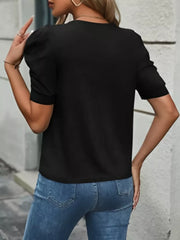 Black t-shirt with short puff sleeves and a crew neck, styled with blue jeans.