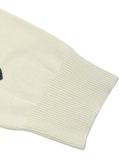 Cream acrylic knit sweater with scattered heart intarsia pattern and ribbed cuffs.