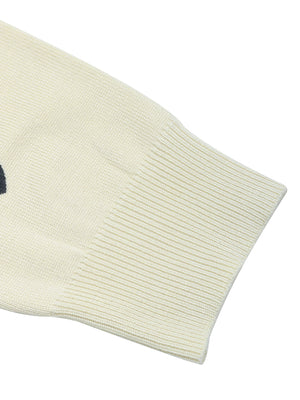 Cream acrylic knit sweater with scattered heart intarsia pattern and ribbed cuffs.