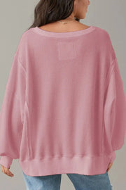 Dusty pink waffle knit pullover sweater with slit sleeves and crew neck.