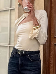 Beige long-sleeve shirt with knot front and one shoulder cutout detail.