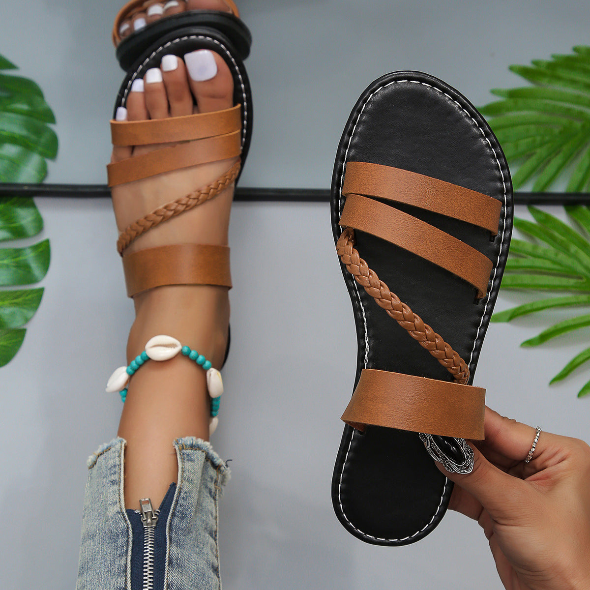 Brown braided strap open-toe flat sandals with multiple straps and ankle wrap detail.