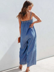 Medium denim jumpsuit with gathered bodice and wide legs.