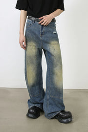 Faded patchwork denim palazzo trousers in medium wash with distressed details and wide leg.