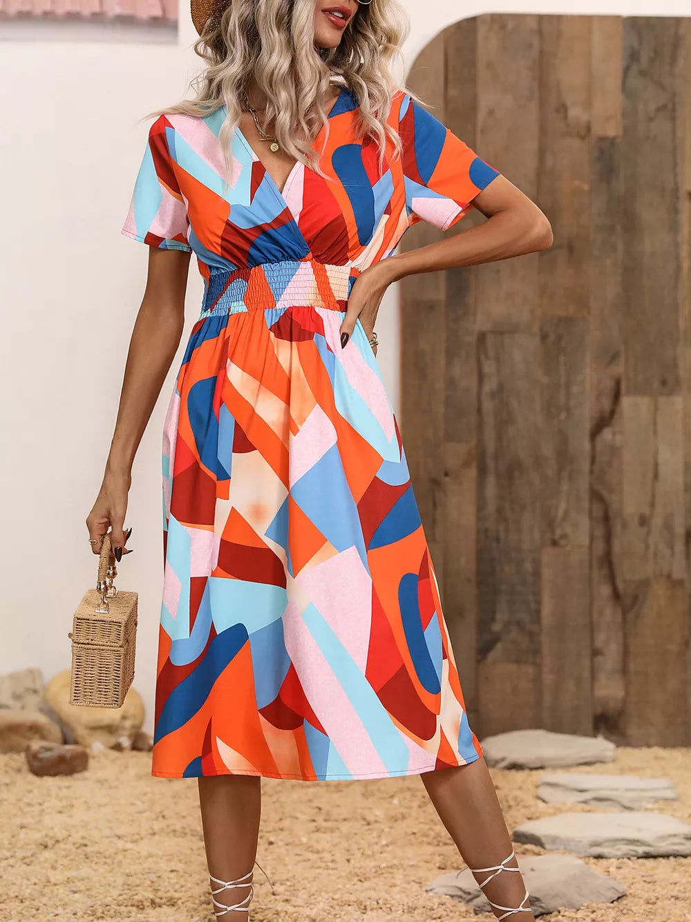 Vibrant abstract pattern midi dress with V-neck, short sleeves, and smocked waist.