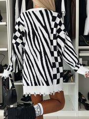 Black and white zebra stripe knit tunic with distressed hem and checkerboard sleeves.