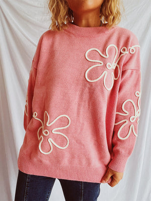 Watermelon pink knit sweater with white floral outline details and crew neck.