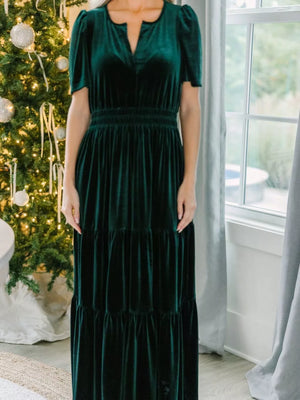 Dark green velvet maxi dress with tiered skirt and short puff sleeves.