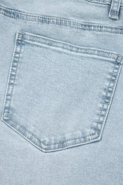 Light wash denim jeans back pocket detail with contrast stitching.