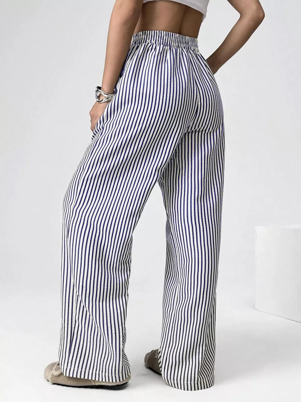 Navy striped high-waisted wide-leg pants with drawstring detail.