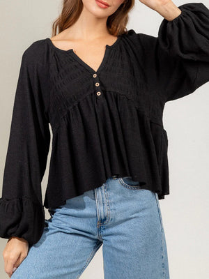 Black textured ribbed peplum blouse with button detail and ruffled cuffs