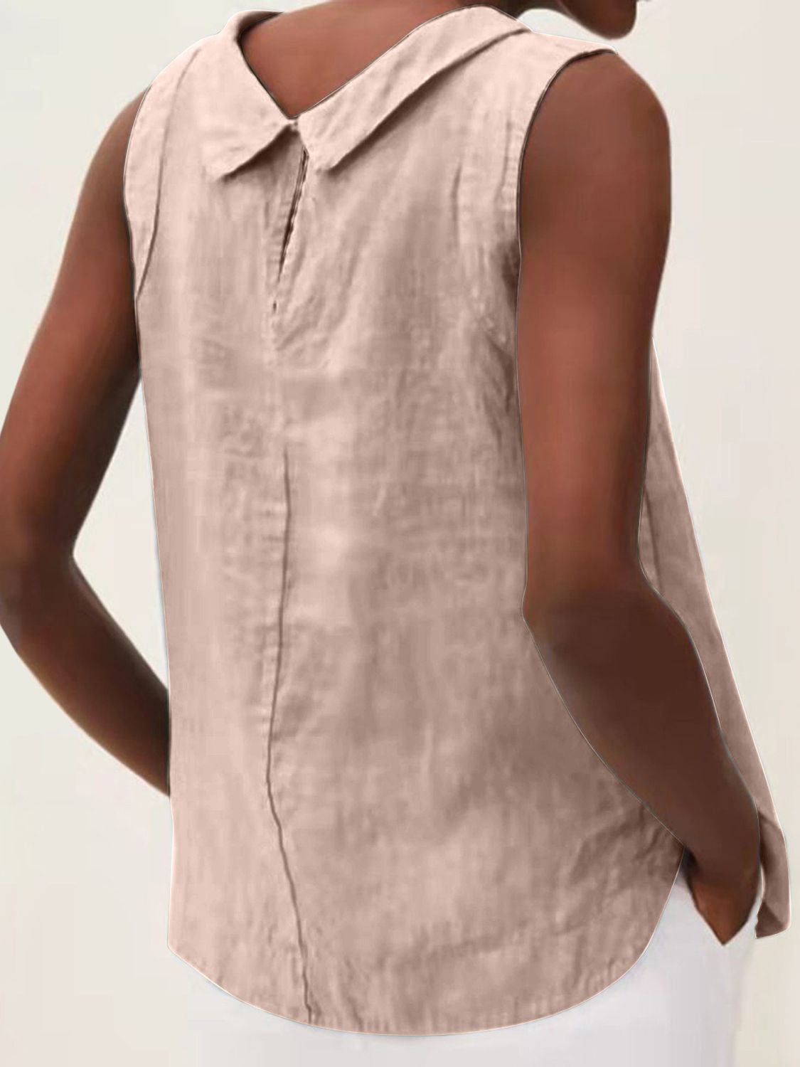 Sleeveless Peter Pan collar blouse in a light pinkish-beige color with a back seam detail.