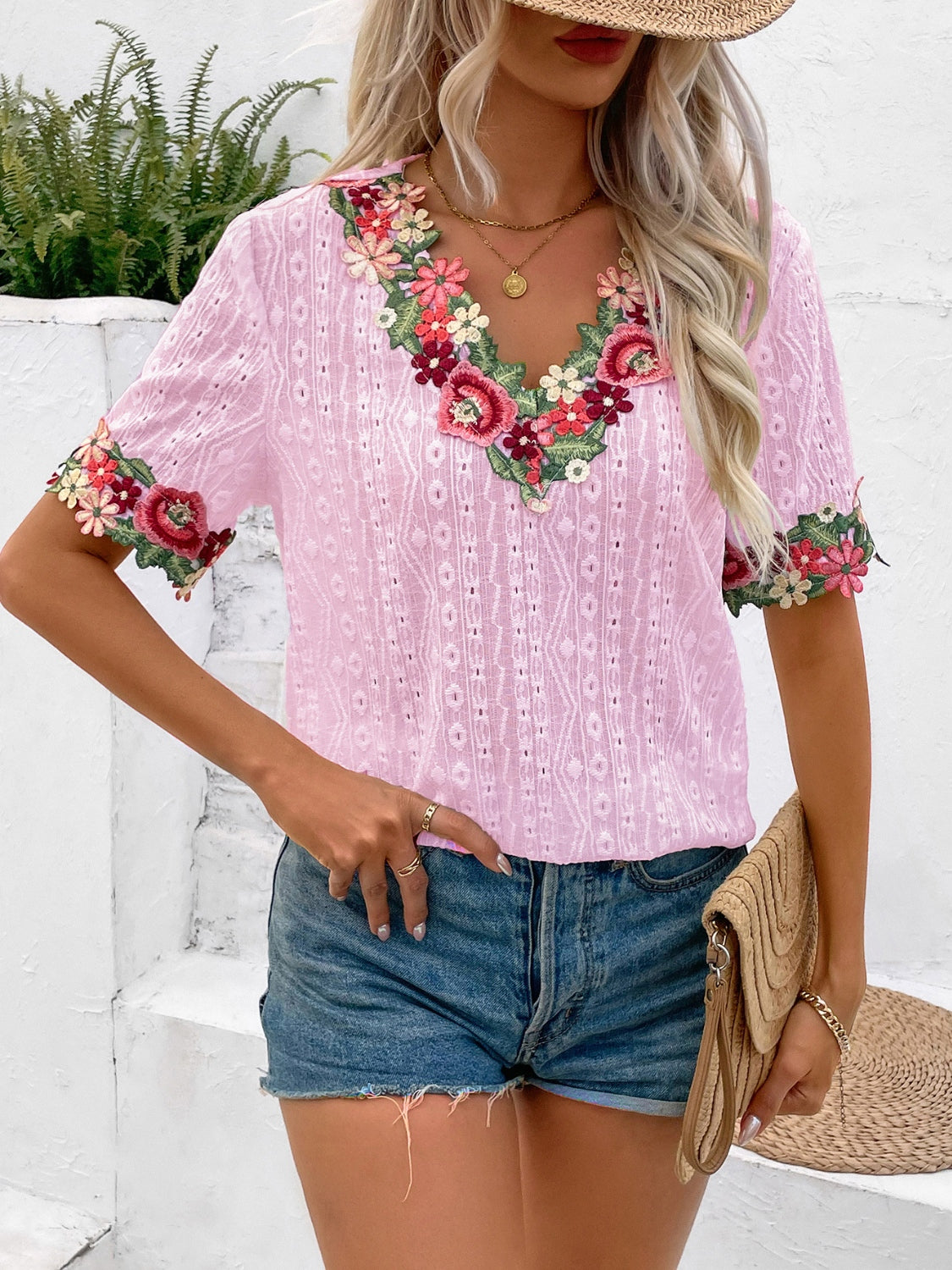 Blush pink eyelet peasant blouse with floral embroidery on V-neck and sleeves.