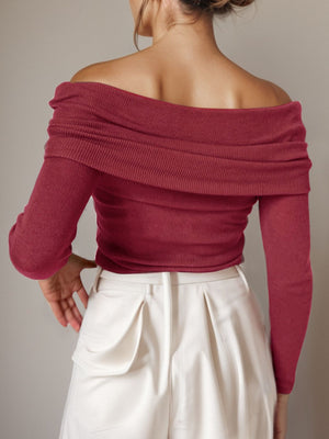 Burgundy knit sweater with off-the-shoulder neckline and long sleeves.