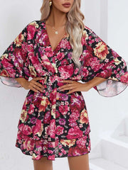 Floral ruffle hem mini dress in black with pink and yellow flowers, V-neck, and flutter sleeves.