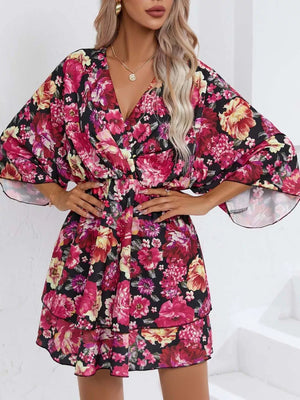 Floral ruffle hem mini dress in black with pink and yellow flowers, V-neck, and flutter sleeves.