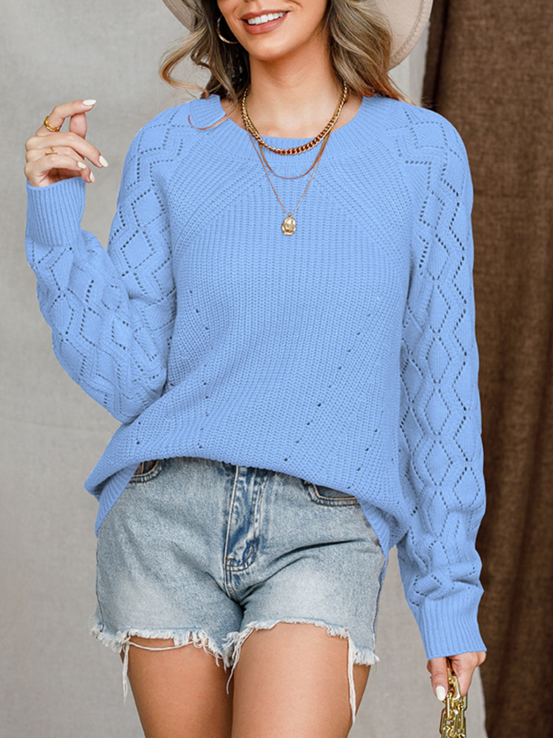 Blue diamond-cut raglan knit sweater with crew neck and long sleeves.