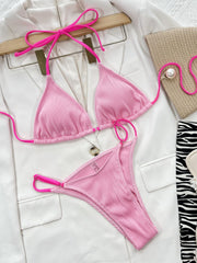 Pink ribbed triangle bikini set with neon pink string ties and hardware detail.