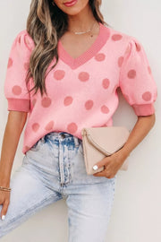 Pink polka dot knit top with puff sleeves and V-neck, styled with light wash jeans.