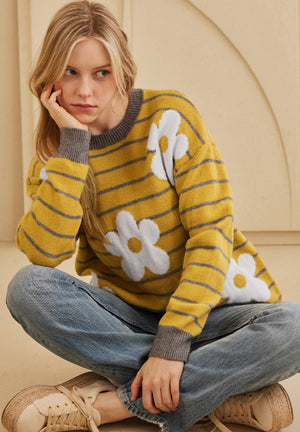 Yellow knit sweater with grey stripes and white daisy intarsia pattern.