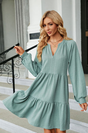 Light green textured babydoll mini dress with voluminous sleeves and tiered hem