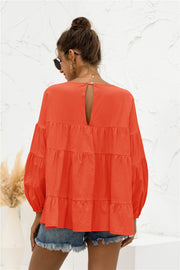 Orange tiered blouse with ruffled bubble sleeves and keyhole back detail
