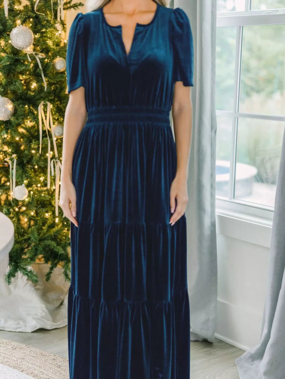 Navy blue velvet maxi dress with tiered skirt and short puff sleeves.