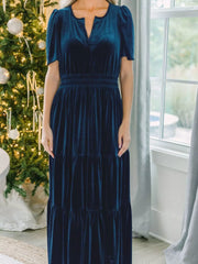 Navy blue velvet maxi dress with tiered skirt and short puff sleeves.