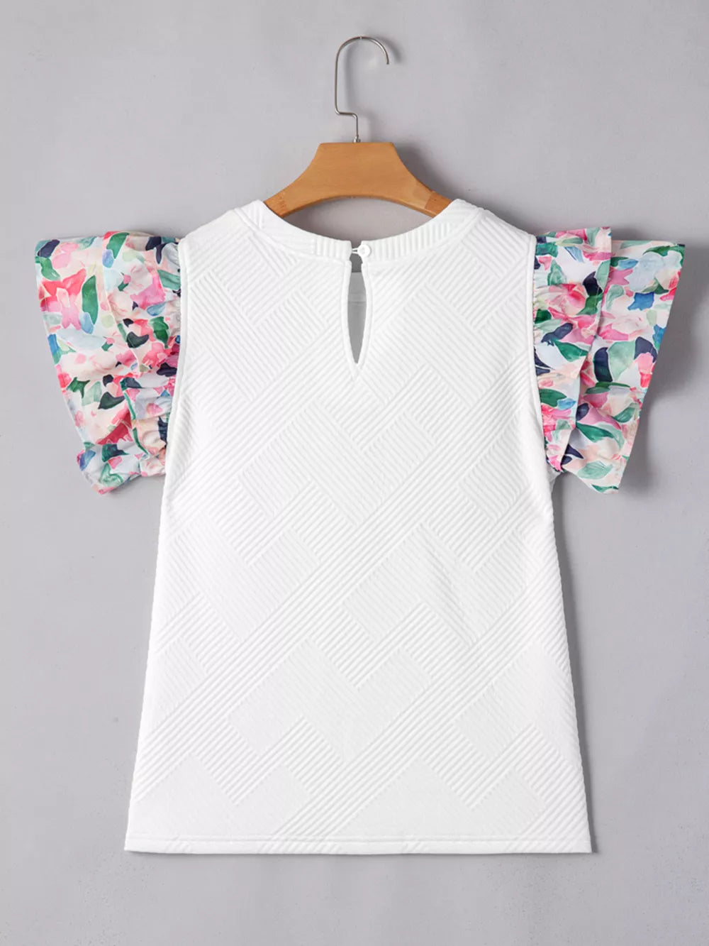 White geometric knit top with floral ruffled sleeves and keyhole back detail.