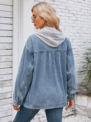 Oversized denim jacket with grey hood detail, buttoned cuffs, and classic blue wash.