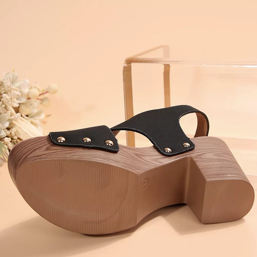 Black crisscross high heel sandals with studs and a wooden platform sole.