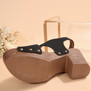 Black crisscross high heel sandals with studs and a wooden platform sole.