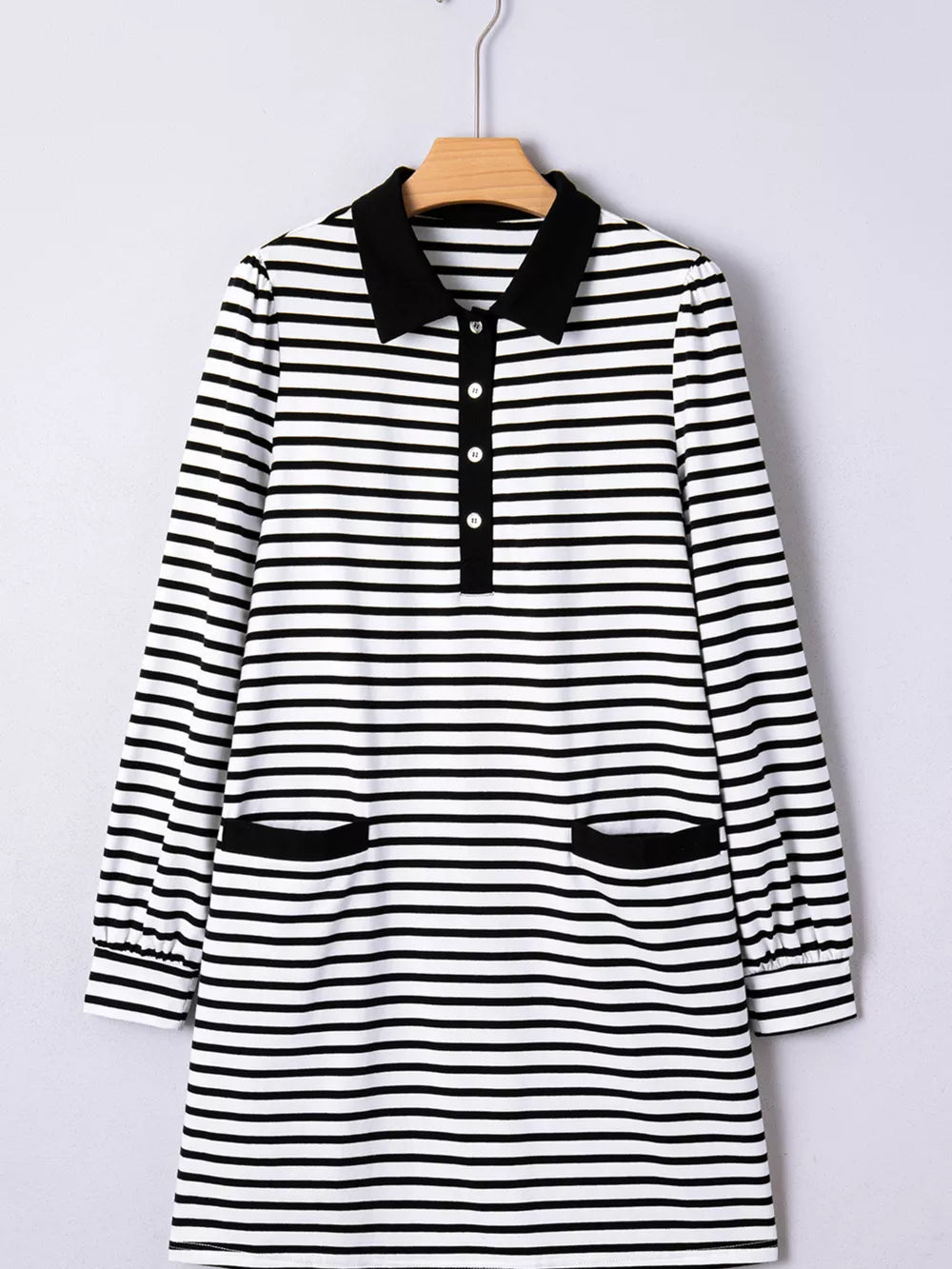 Black and white striped collared long sleeve dress with button front and two front pockets.