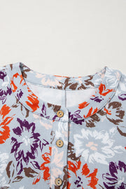 Floral cap-sleeve jumpsuit with button detail and wide legs.