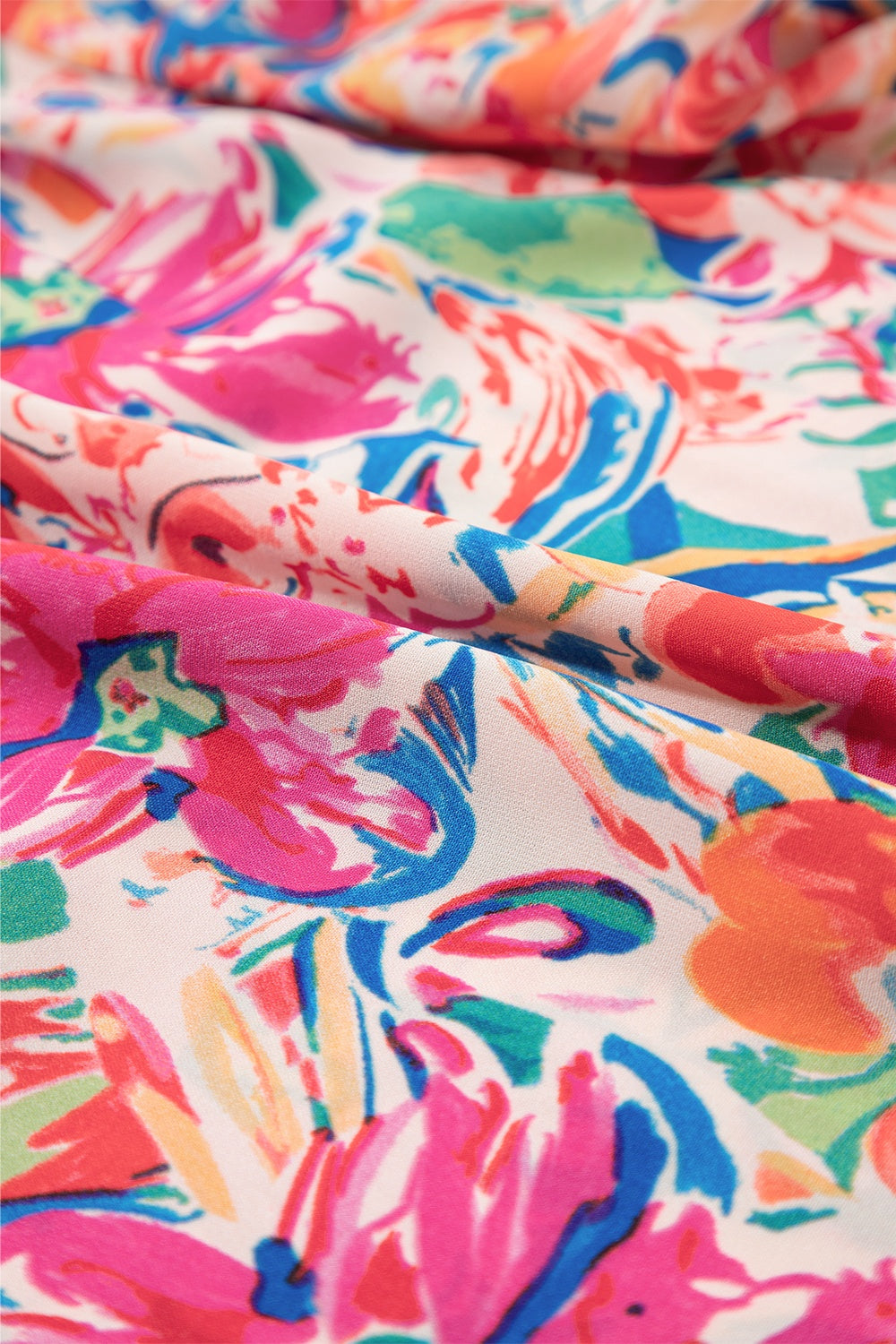Floral blouse with flutter sleeves and tie-neck detail in a vibrant floral print.